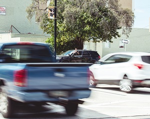 Police running speed radar with two cars passing